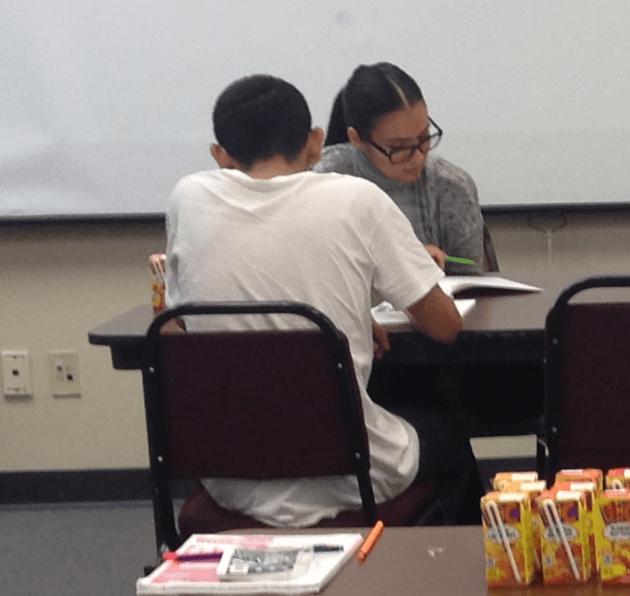 Volunteer tutor from the University of Central Oklahoma providing one-on-one literacy assistance to an OCJB client .